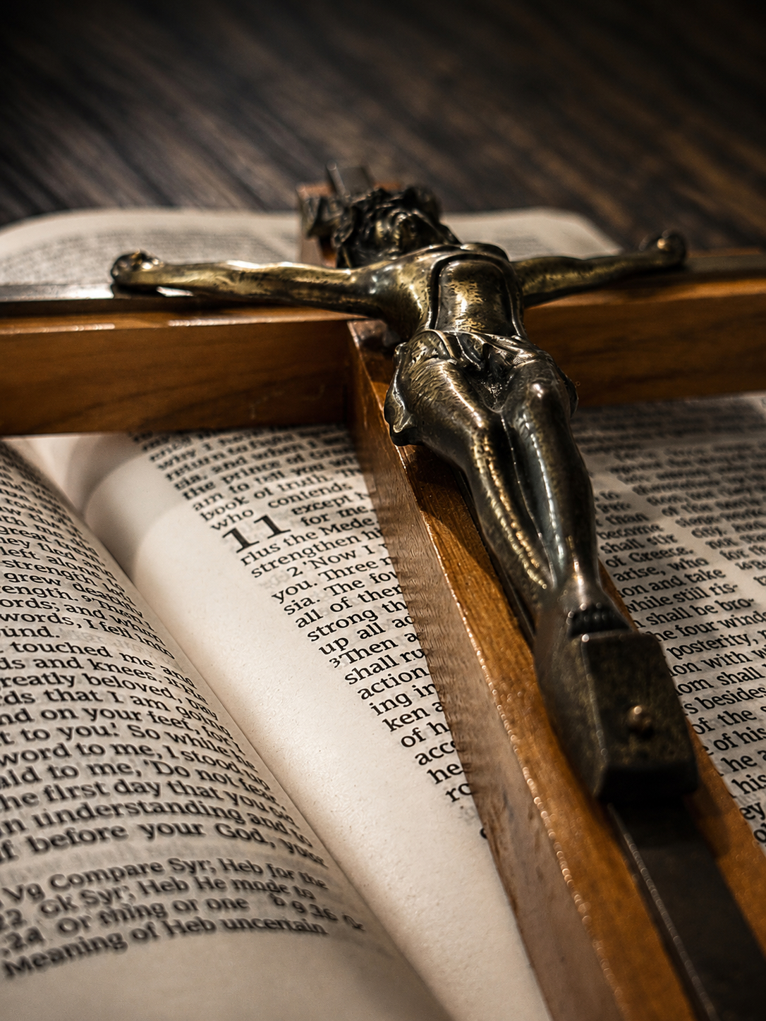 Crucifix resting on open Bible pages — In Faith We Testify Christian testimony podcast