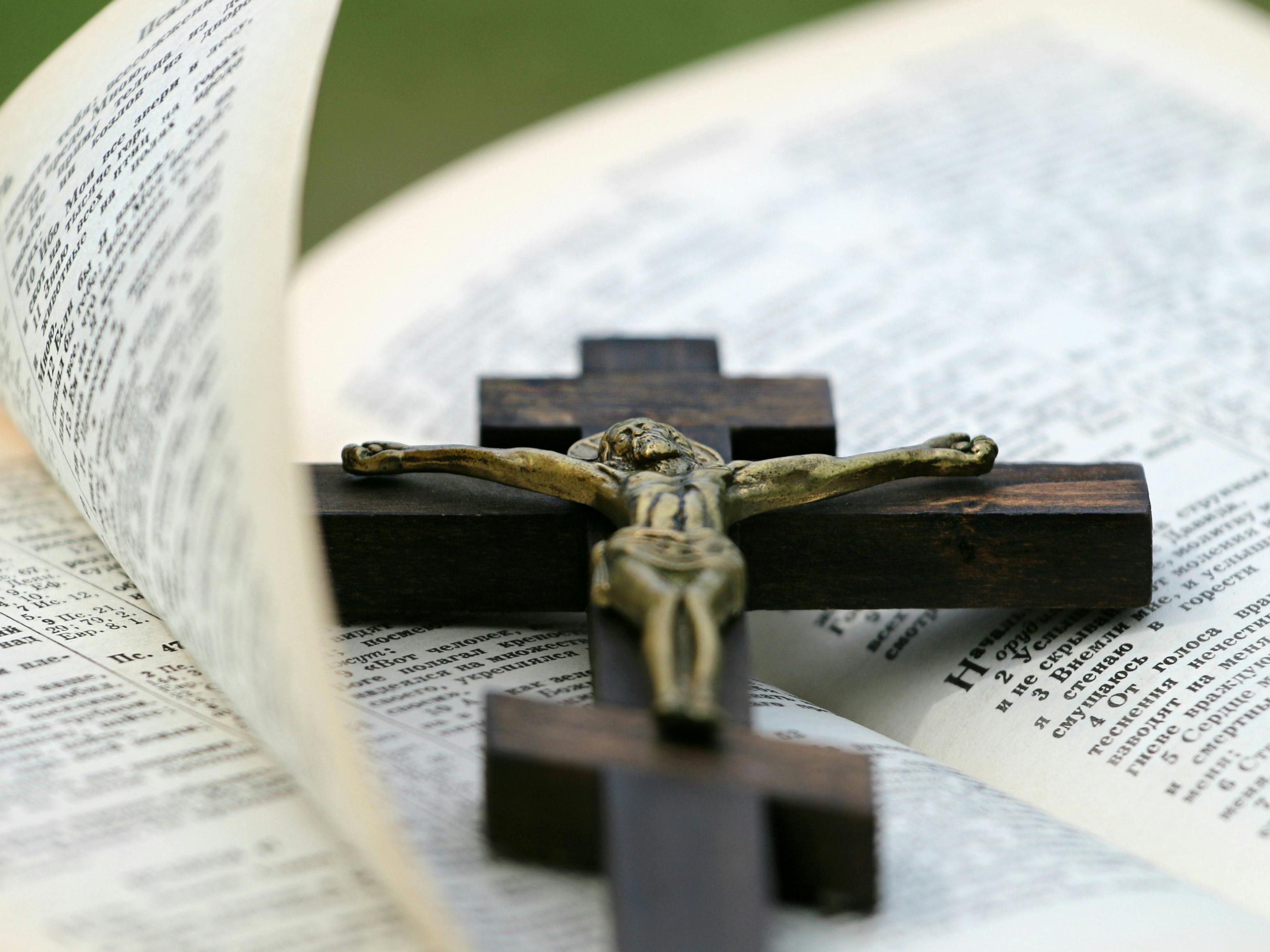 Crucifix resting on open Bible pages